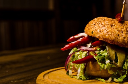 Bacon burger with beef patty on wooden tableの写真素材