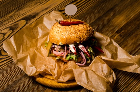 Bacon burger with beef patty on wooden tableの写真素材