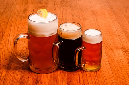 Variety of different beers, of different colors and alcoholic strengths in different shaped glasses suited to different personalitiesの写真素材