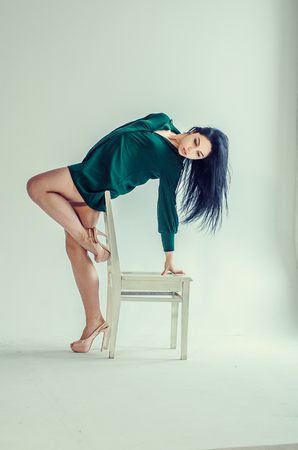Semi-nude beautiful girl posing on a chair in a classic suit.の写真素材