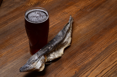 Beer with dried fish and snacks on wooden table.の写真素材