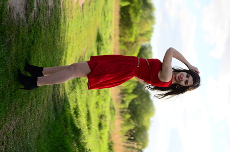 Happy smile girl on the beautiful old city square dancing in the rain, wears stylish red velvet short dress.の写真素材