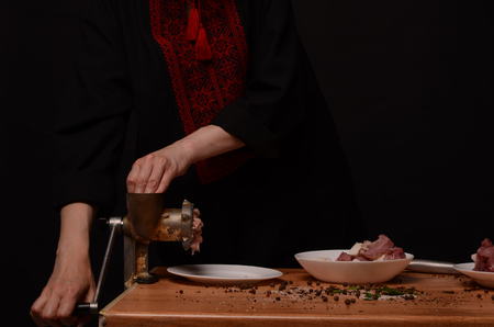 Woman stirring cooked minced meat in kitchen.