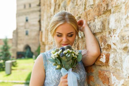 Happy bride and groom walking on gren golf course outdoors, copy space. Wedding couple in love, newlyweds. Wedding concept, bridal bouquet in bride's hands Lutsk Ukraine 04.08.2018.のeditorial素材