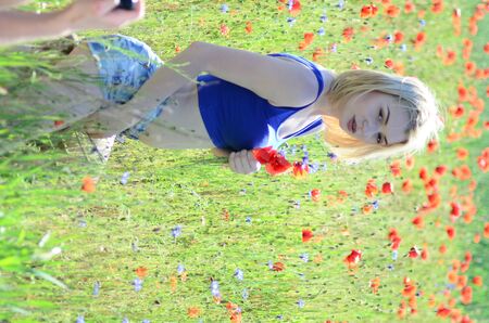 Girl with a wreath of flowers. Face of beautiful ukrainian girl in a wreath of summer flowers on nature. Girl on the field with poppies. Fantasy art photography Lutsk, Ukraine, May 28, 2018のeditorial素材