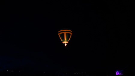 Hot air balloon flying over spectacular Cappadocia under the sky with milky way and shininng star at night (with grain).の写真素材
