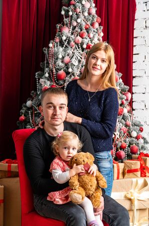Family at Christmas with the boy. New Year photo session in the studio. Dad and his mom on holidays communicate with his son in the living room. Lutsk, Ukraine 28.12.18のeditorial素材