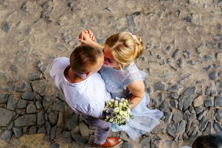 Happy bride and groom walking on gren golf course outdoors, copy space. Wedding couple in love, newlyweds. Wedding concept, bridal bouquet in bride's handsのeditorial素材