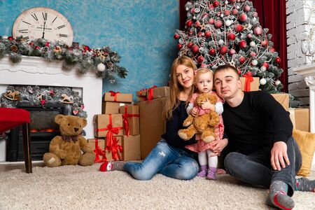 Family at Christmas with the boy. New Year photo session in the studio. Dad and his mom on holidays communicate with his son in the living room. Lutsk, Ukraine 28.12.18のeditorial素材