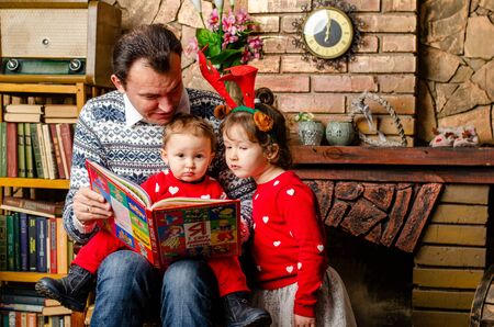 Family at Christmas with the boy. New Year photo session in the studio. Dad and his mom on holidays communicate with his son in the living room. Lutsk, Ukraine 28.12.18のeditorial素材