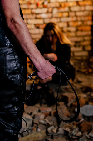 Home violence: Woman covering her child from angry husband with belt. Aggression in the familyの写真素材