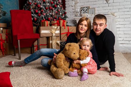 Family at Christmas with the boy. New Year photo session in the studio. Dad and his mom on holidays communicate with his son in the living room. Lutsk, Ukraine 28.12.18のeditorial素材