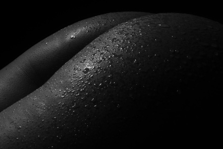 Black and White Beautiful woman body. Fashion art studio portrait of elegant naked lady with shadow on her. Female stomach isolated on black background. Erotic pose low key shootの写真素材