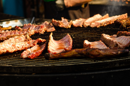 Spare ribs cooking on barbecue grill for summer outdoor party. Food background with barbecue party.の写真素材