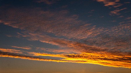 Sky blue and orange light of the sun through the clouds in the sky