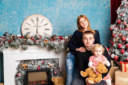 Family at Christmas with the boy. New Year photo session in the studio. Dad and his mom on holidays communicate with his son in the living room Lutsk, Ukraine 28.12.18のeditorial素材