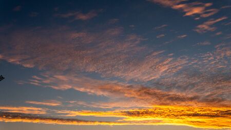 Sky blue and orange light of the sun through the clouds in the sky