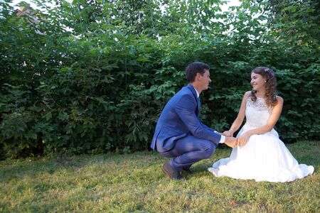 Cute wedding couple in ukrainian traditional clothes sitting on the bench in the town and spending time togetherのeditorial素材