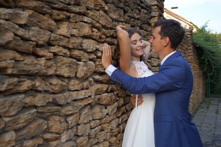 Cute wedding couple in ukrainian traditional clothes sitting on the bench in the town and spending time togetherのeditorial素材