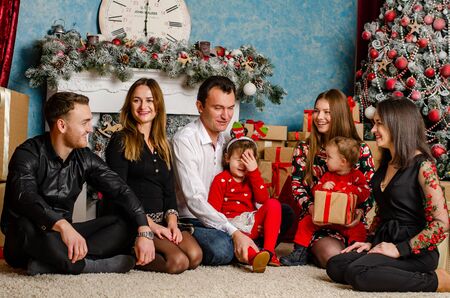 Family at Christmas with the boy. New Year photo session in the studio. Dad and his mom on holidays communicate with his son in the living room. Lutsk, Ukraine 28.12.18のeditorial素材