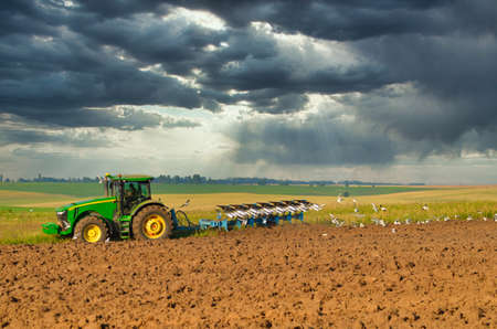 Lutsk Ukraine Farmer in tractor preparing land with seedbed cultivator as part of pre seeding...