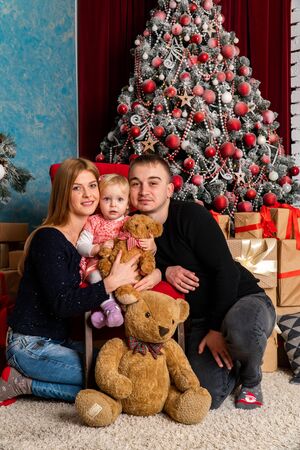 Family at Christmas with the boy. New Year photo session in the studio. Dad and his mom on holidays communicate with his son in the living room. Lutsk, Ukraine 28.12.18のeditorial素材