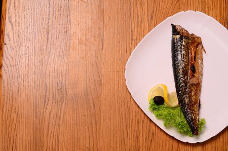 Smoked mackerel with vegetables grilled on a white plate. Beautiful exposure tasty Mediterranean dishes. Professional kitchen. Photo for culinary magazines, posters, websites and backgroundsの写真素材