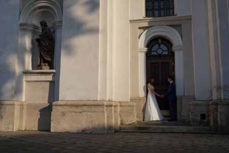 Cute wedding couple in ukrainian traditional clothes sitting on the bench in the town and spending time togetherのeditorial素材