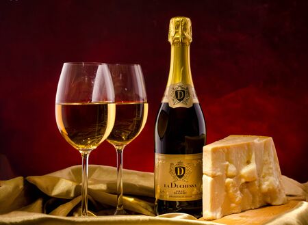 Red wine, assorted cheeses, bread and grapes in a still life setup.のeditorial素材