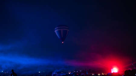 Hot air balloon flying over spectacular Cappadocia under the sky with milky way and shininng star at night (with grain)の写真素材