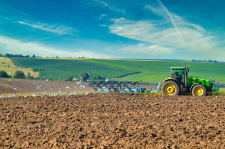 Lutsk Ukraine Farmer in tractor preparing land with seedbed cultivator as part of pre seeding activities in early spring season of agricultural works at farmlands. 10.07.2017のeditorial素材