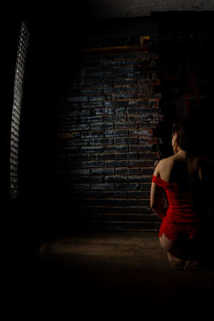 Beautiful brunette woman posing in red lingerie on red background. Brunette woman posing in red bodysuit in studio. Fit sporty girl. Concept of beauty, fashion and style. Valentines day.の写真素材