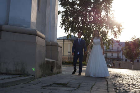 Cute wedding couple in ukrainian traditional clothes sitting on the bench in the town and spending time togetherのeditorial素材