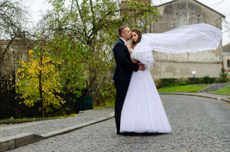 Cute wedding couple in ukrainian traditional clothes sitting on the bench in the town and spending time together Lutsk Ukraine 16.01.19.のeditorial素材