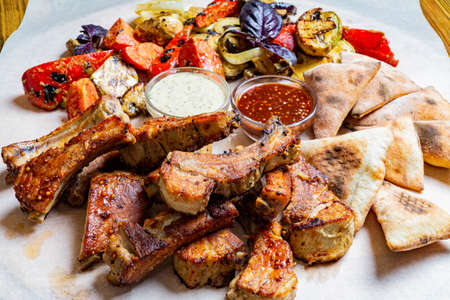 Buffalo chicken wings with cayenne pepper sauce served hot with celery sticks and carrot sticks with...