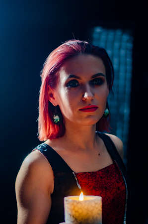 Fashion shoot of beautiful woman in a long dress over dark background