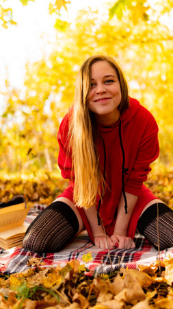 Incredible stunning girl in a red dress. The background is fantastic autumn. Artistic photography.の写真素材
