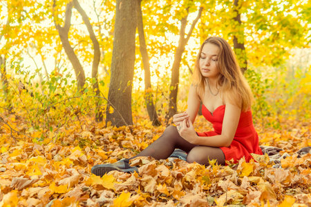A woman is posing in front of a camera in an autumn park. autumn photo shoot. Autumn in the park.の写真素材