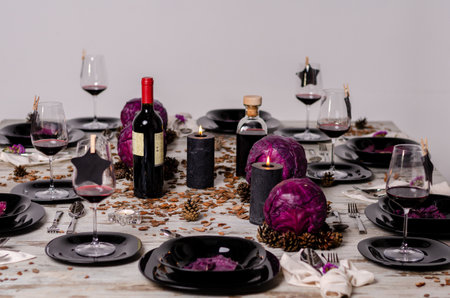 Festive table setting with red wine, candles and purple cabbage.の写真素材