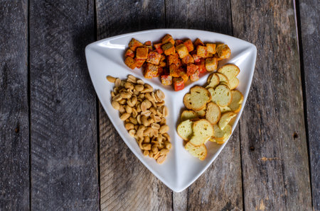 Crispy crackers with croutons on wooden background.の写真素材