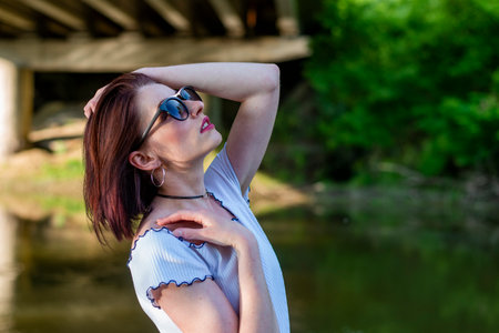 A gorgeous brunette model poses outdoors while enjoying the spring weather.の写真素材