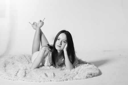 Fashion photo of beautiful and young lady in swimsuits posing in studio on whiteの写真素材