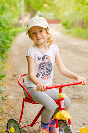 Little girl with a tricycle in the parkの写真素材