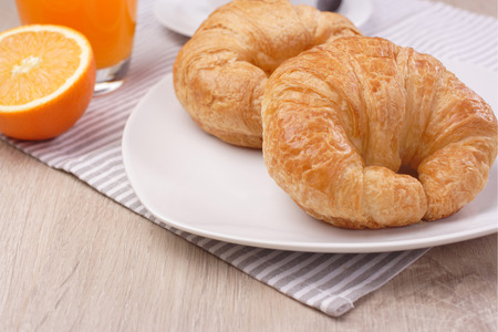 Breakfast croissant and orange juice on woodenの写真素材