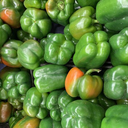 photo of a set of green peppers on a wooden platform