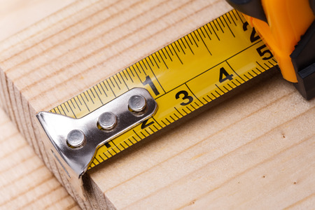 Yellow steel tape measure on wooden plank. Repair and building conceptの写真素材