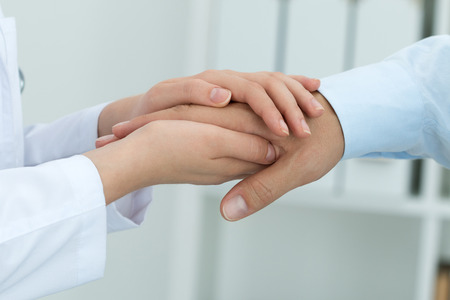 Female medicine doctor reassuring her patient. Hands close-up. Healthcare and medical concept.の写真素材