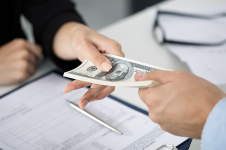 Woman taking batch of hundred dollar bills. Hands close upの写真素材
