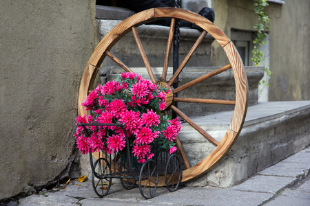Flowered wagon with antique old wheel before stairs on Tallinn street.の写真素材