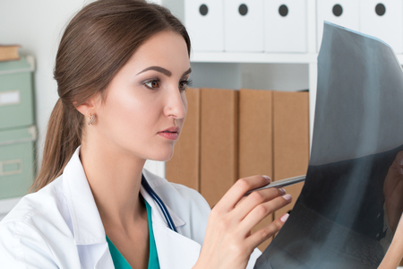 Young female doctor looking at lungs x-ray image. Healthcare and medical conceptの写真素材